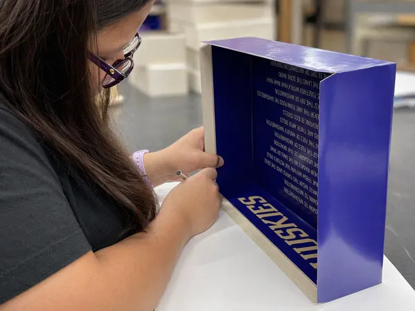 Custom rigid presentation box being assembled in the bindery