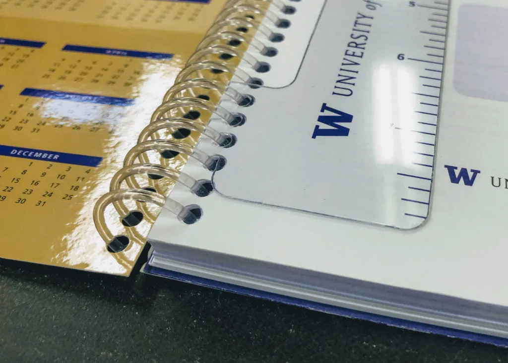 Wire-O bound book laying flat on a desk